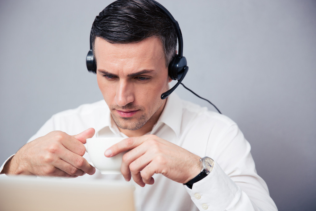 Businessman in headphones drinking coffee
